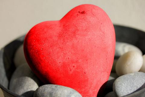 A heart-shaped rock has been painted red.