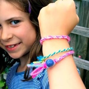 A girl shows off the friendship bracelets on her wrist.